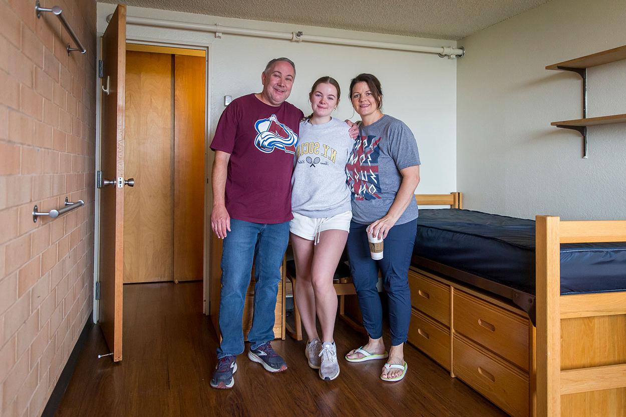 A family poses with their student in their new dorm room.